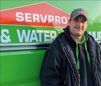 Male employee, Joe, standing in front of SERVPRO van
