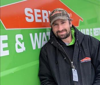 Male employee, Dave, standing in front of SERVPRO green vehicle