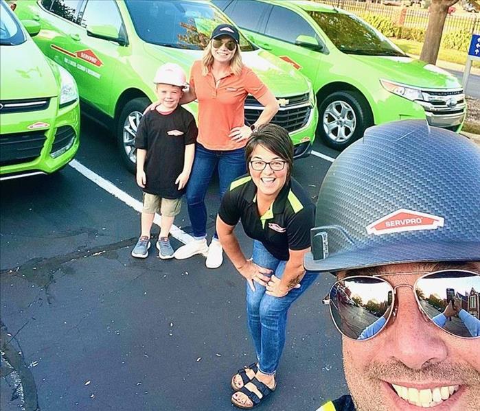 SERVPRO Marketing Team standing in front of green SERVPRO vehicles