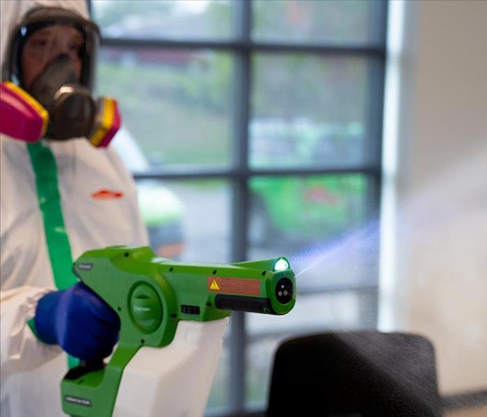 SERVPRO professional fully suited up in PPE spraying ServprOXIDE™