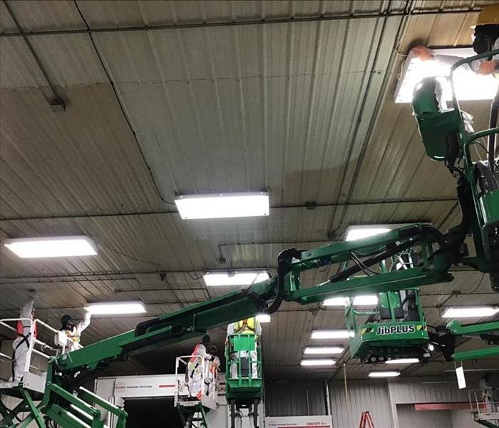 SERVPRO professionals cleaning soot from commercial building ceiling